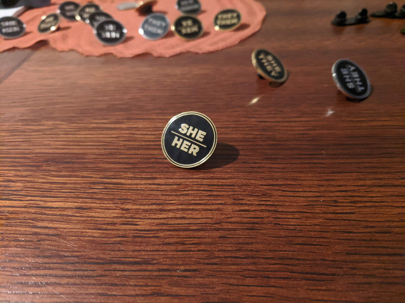 [Australia] - She Her Pronoun Pin Black and Gold Circular Hard Enamel Pronoun Button Badge 